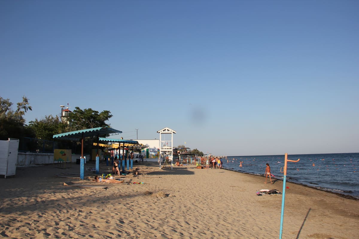 Cape Cod beach in full summer swing - colorful umbrellas and families enjoying the sun